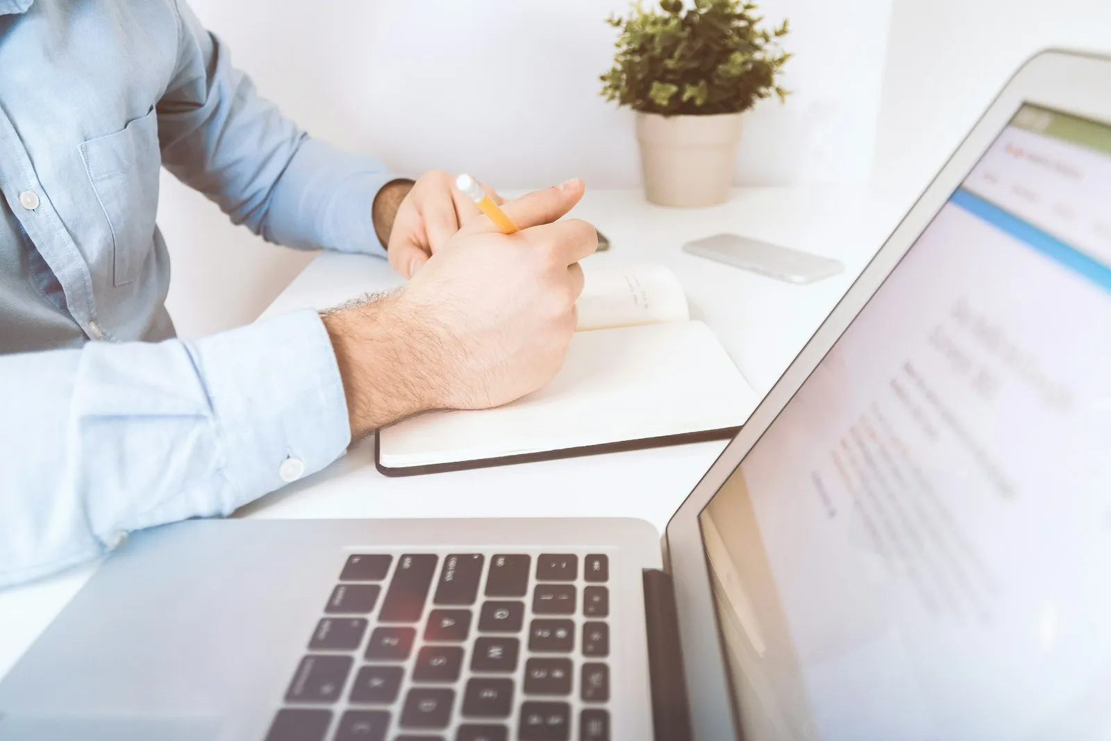 Médecin prenant des notes à côté de son ordinateur