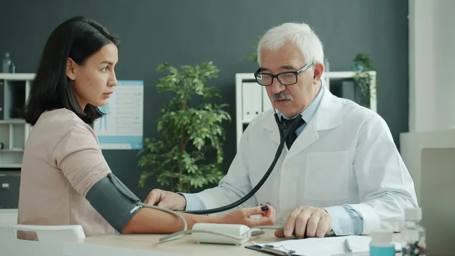 Médecin prenant la tension d'une patiente lors d'une consultation