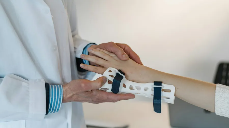 Médecin ajustant une attelle au poignet d'une patiente