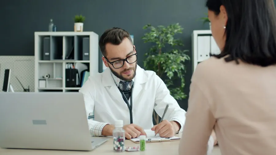 Médecin recevant une patiente en consultation à son bureau